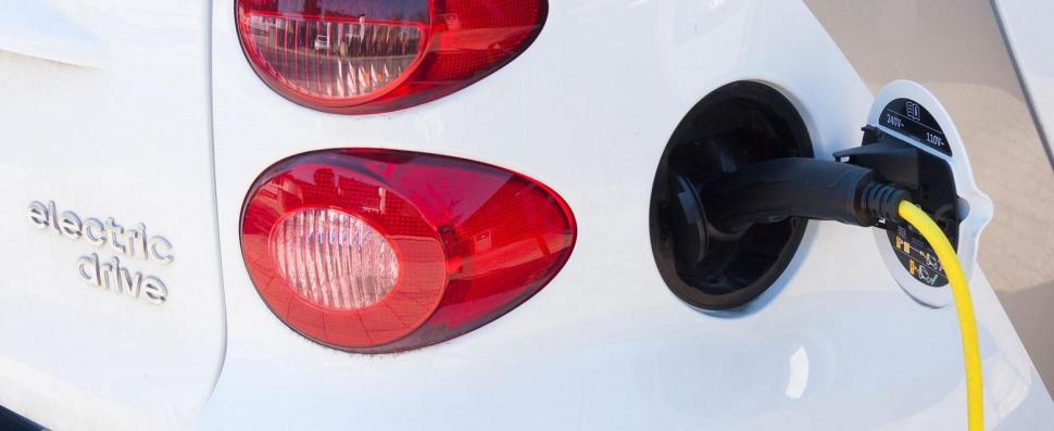 Weißes Auto der Marke Smart wird gerade elektronisch geladen